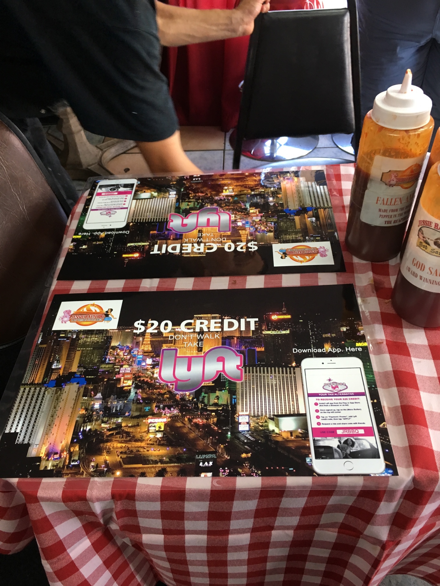 Lyft $20 credit referral placemats on the tables of a barbecue restaurant