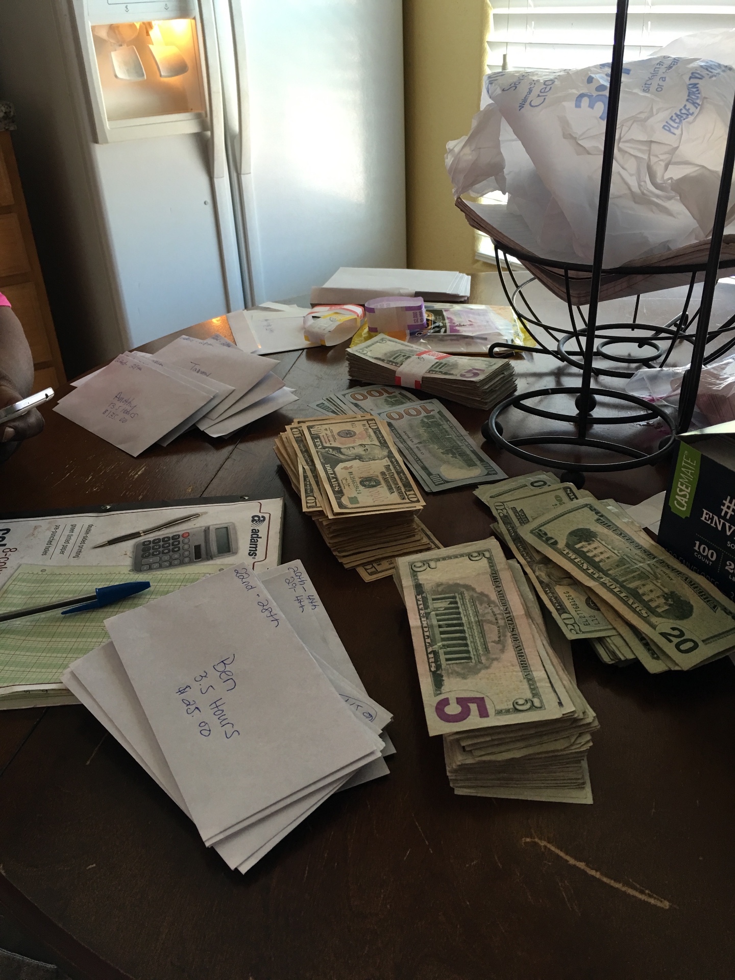 Team payout day with stacks of cash sorted into labeled envelopes by team member